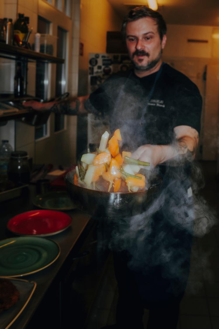 Koch bei Kochsternstunden Schleswig-Holstein brät knackiges Gemüse in dampfender Pfanne im Wettbewerb der Kieler Nachrichten.