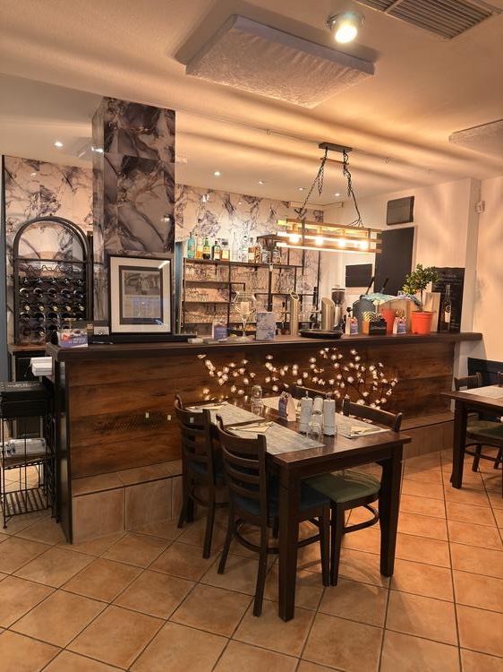 Gemütliches Restaurantinterieur eines Teilnehmers der Kochsternstunden in Schleswig-Holstein mit stilvollem Barbereich und dekorierten Tischen.